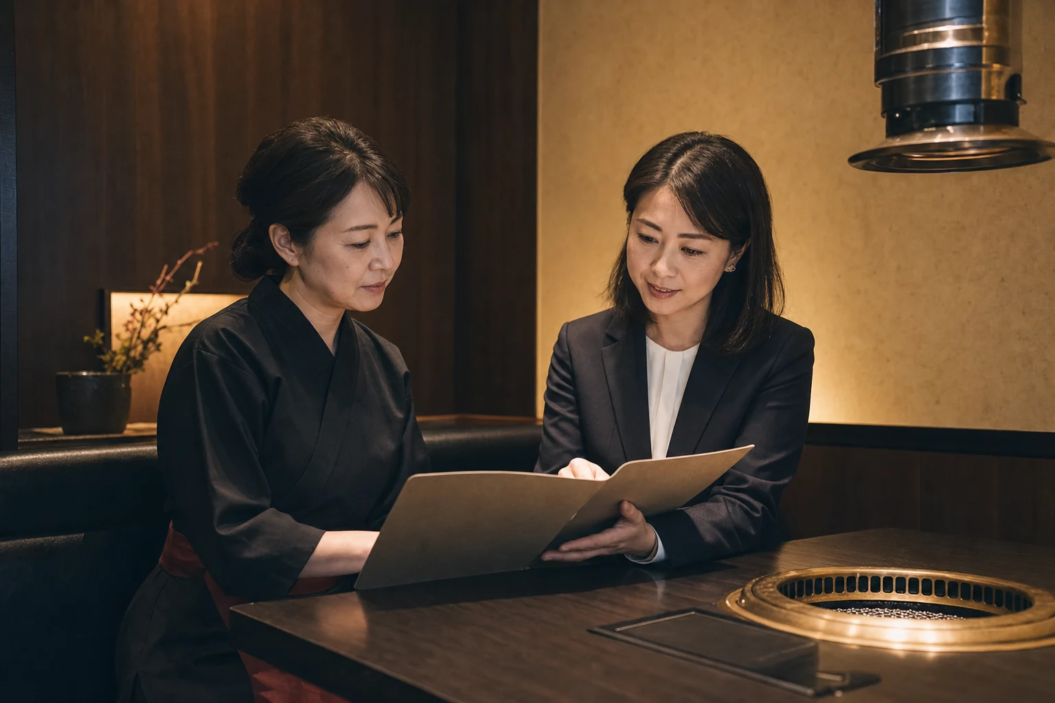 個室で焼肉店の譲渡について相談する経営者と担当者